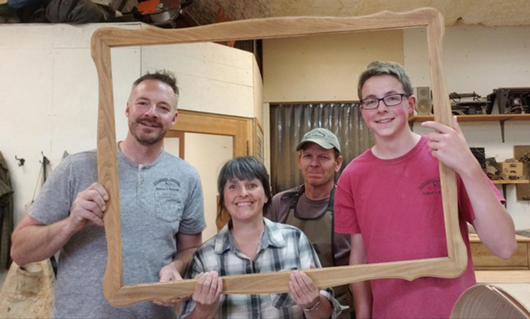 Happy Family posing while holding an empty frame